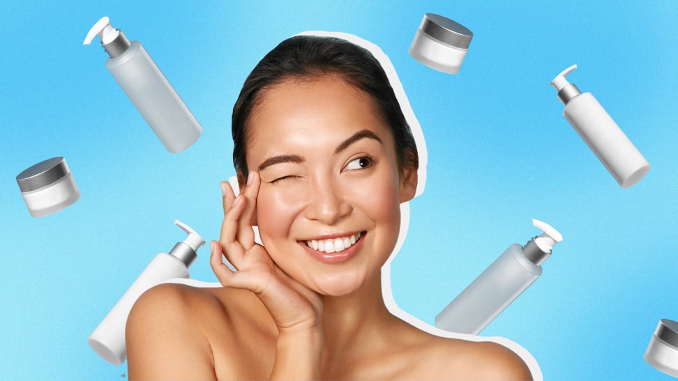 Person smiling while using two fingers to rub products into skin while surrounded by moisturizer bottles.