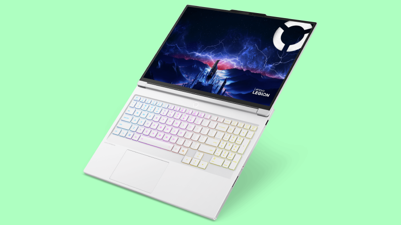 A sleek white Lenovo Legion laptop with a vibrant RGB backlit keyboard and a stunning display showcasing a futuristic landscape, set against a bright green background.