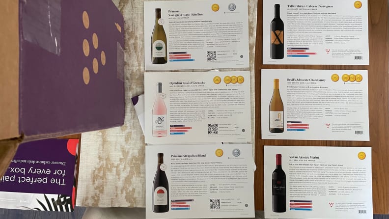 Several Firstleaf informational cards for each wine bottle next to a Firstleaf cardboard shipping box.