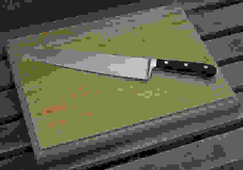 A cutting board with butcher's knife.