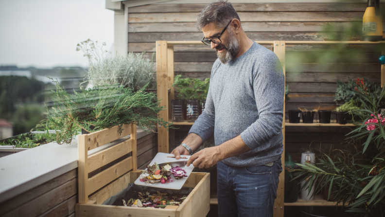 Man adding vegetables to his compost