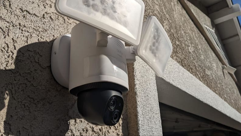 The Eufy Floodlight Camera E340 shown mounted on the exterior of a beige home.