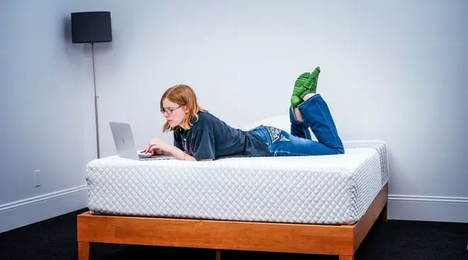 Leesa mattress being used by a woman in a room.