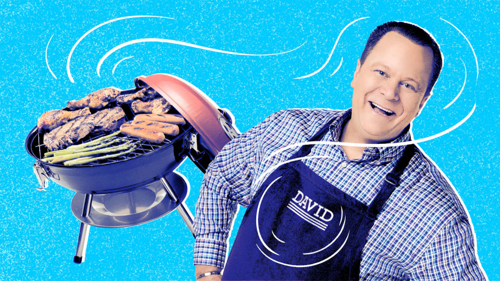 David Venable, QVC host, against a blue background with a grill fired up in the background.