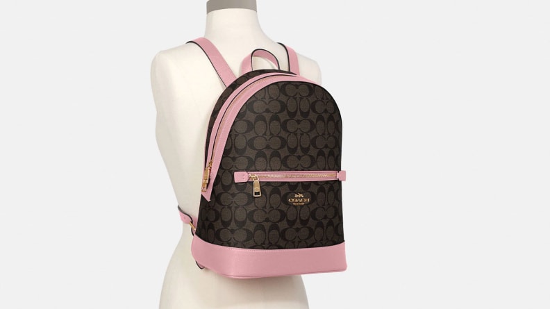 A brown Coach backpack with pink trim.