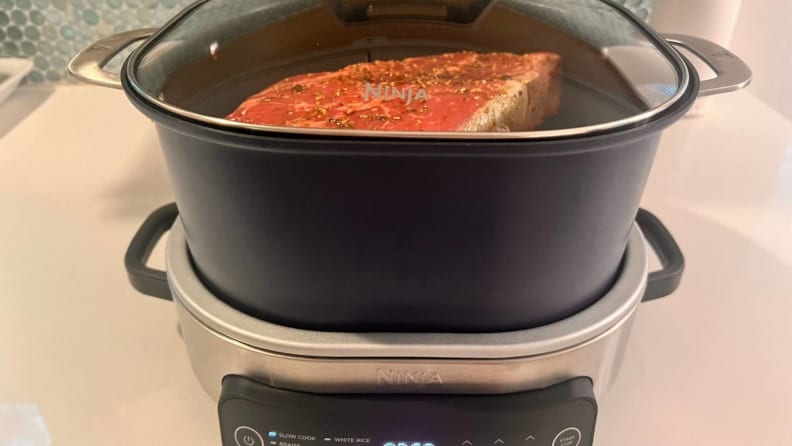 A piece of meat cooking in the Ninja Foodi Possible Cooker