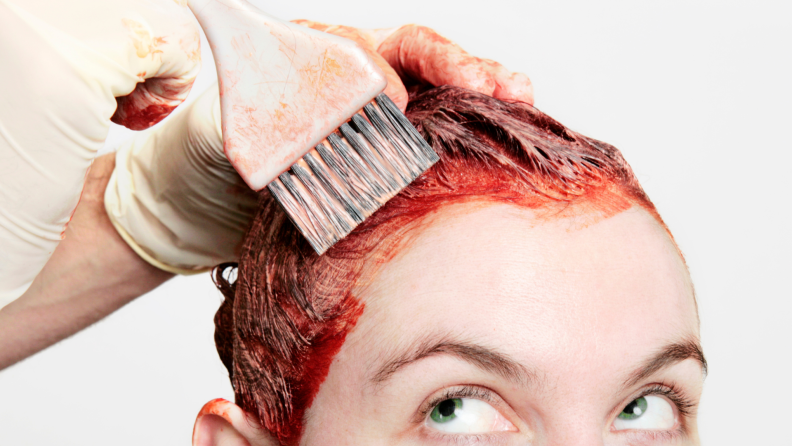 A woman getting her hair dyed red