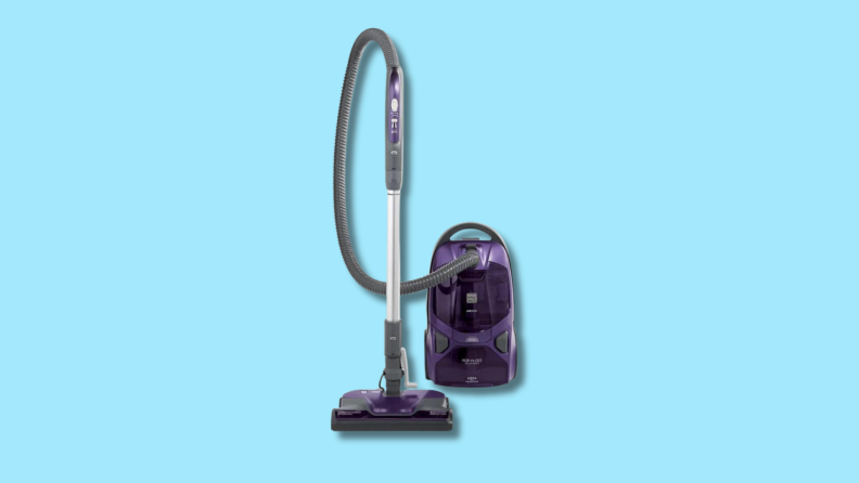 A canister vacuum on a blue background.