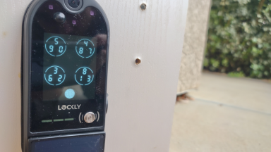 The Lockly Vision Elite keypad smart door lock with camera hangs on a front door