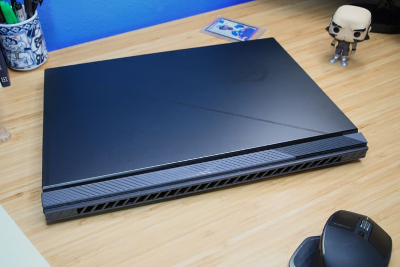 A black laptop on a light brown desk