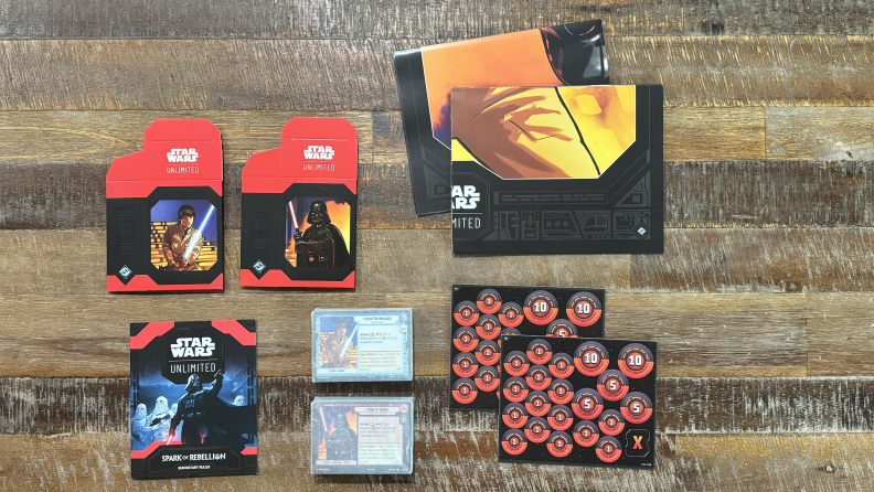 The contents of the Star Wars: Unlimited two-player starter kit on a wooden coffee table.