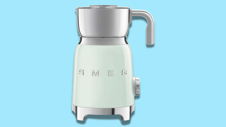 A Smeg milk frother against a blue background.