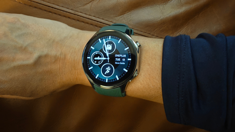 A home display for the OnePlus Watch 2 showing three icons on a classic radial clock face.