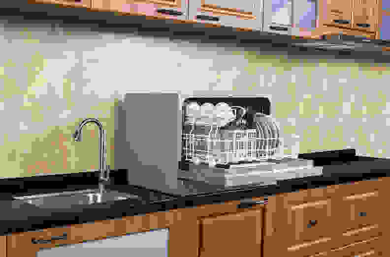 A countertop dishwasher sits atop a kitchen counter.