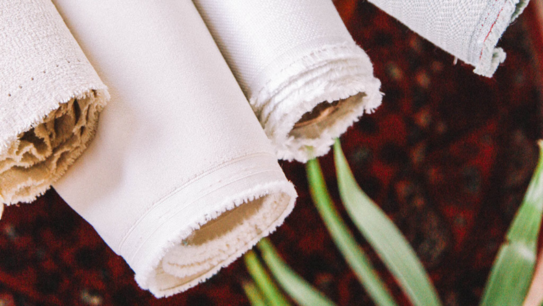 Bolts of fabric stacked against each other.