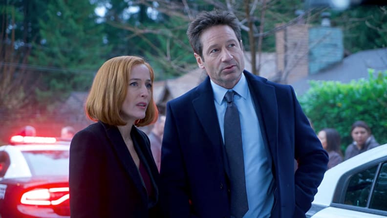 A still from the rebooted season of the X-files featuring Scully and Mulder standing in front of a crime scene.