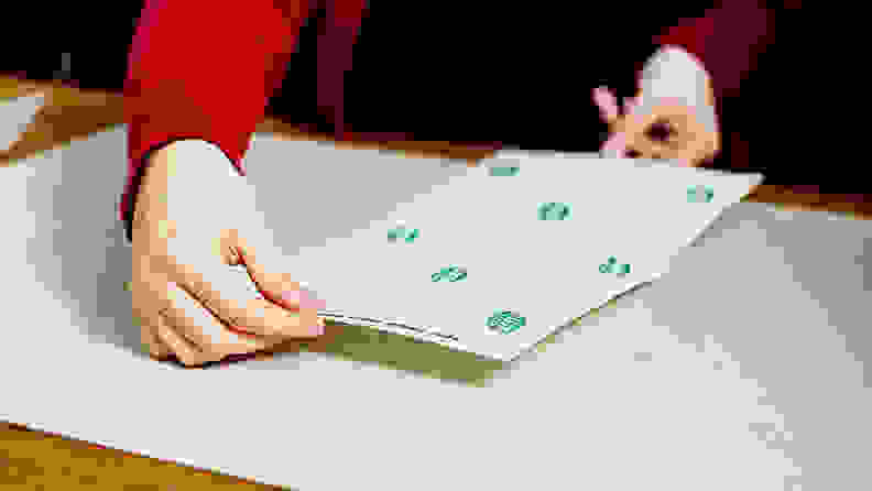 Women sticking sheet to a back of a puzzle