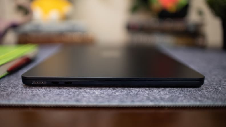Ноутбук MacBook Air 13 M2 темно-синего цвета, вид сбоку: порт для зарядки закрыт на синей ткани.