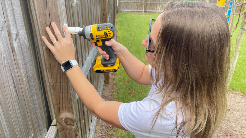 A person installing a home security camera outdoors