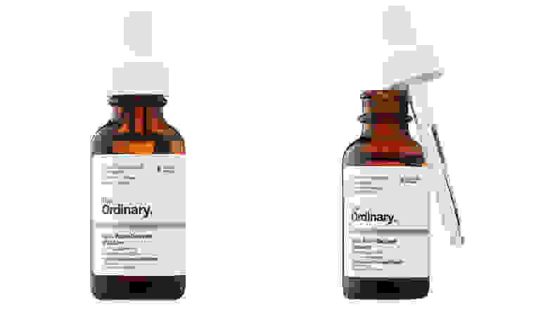 Two amber colored bottles of serum on a white background.