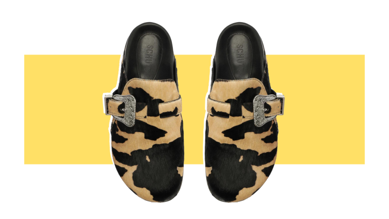 A pair of calf hair clogs that have a leopard print.