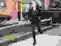 A woman running down the sidewalk wearing an all black outfit and Lululemon sneakers