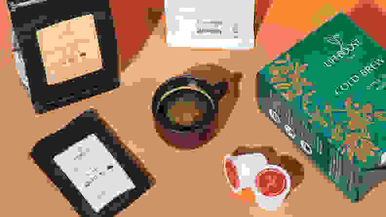 A cup of coffee next to Lifeboost Coffee products on an orange background.