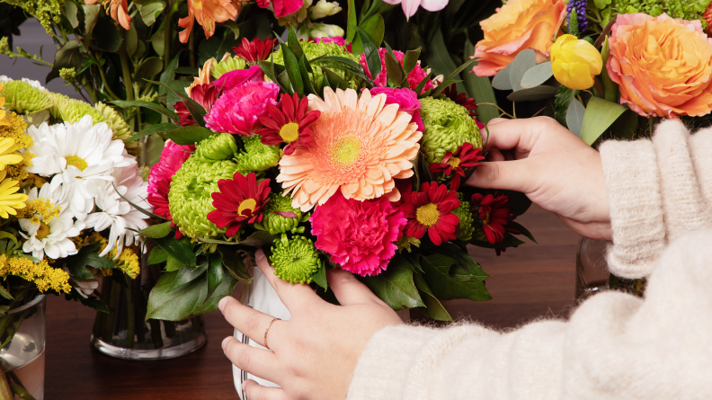 A person's hands touching a bouquet.