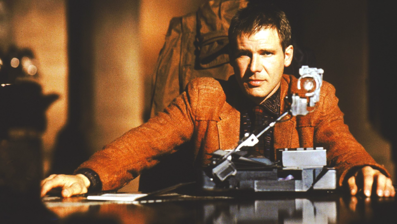 Harrison Ford sits beside a small machine (the Voight-Kampff test) in the 1982 film Blade Runner.