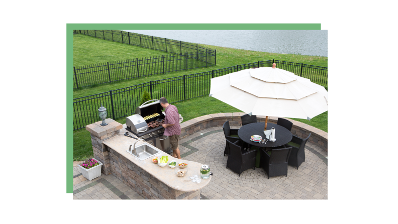 A person grills outside on a patio.