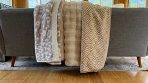 Three throw blankets placed on a couch