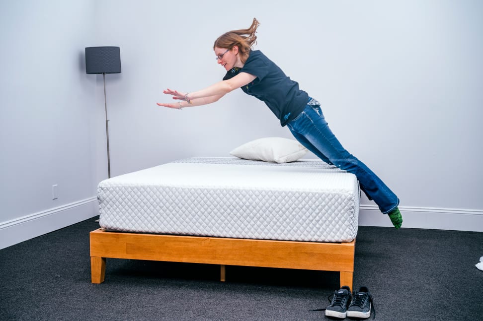 A person jumping onto a mattress.