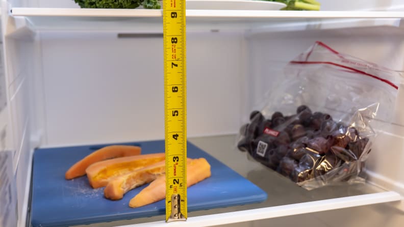 A close-up of the Samsung RS27T5561SR side-by-side refrigerator's shelves, with measuring tape to show each shelf has about 9 inches of clearance.