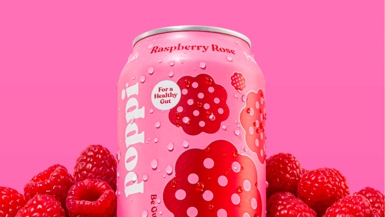 An image of a can of Raspberry Rose Poppi soda surrounded by raspberries.