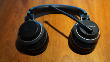 The Turtle Beach Stealth Pro gaming headset on a wooden desk surface.