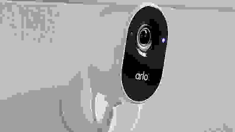 White and black smart camera mounted on wall.