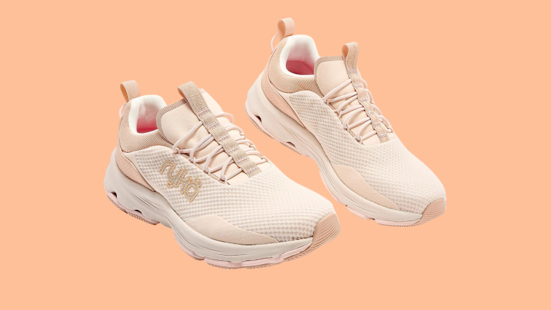 beige athletic sneakers on orange background